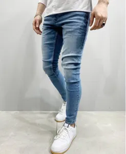 Close-up detail of men's light blue slim-fit skinny jeans showing stretch denim texture.