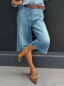 Detailed view of high waisted straight capri denim jeans in light blue with brown belt.