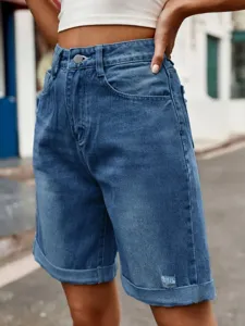 High-waisted blue denim shorts detail featuring cuffed hem and classic five-pocket style.