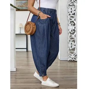 Pantalon sarouel en jean bleu lavé taille haute grande taille femme avec boutons stylés.