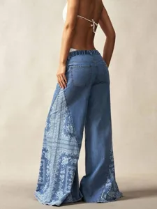 Bohemian style wide-leg denim pants featuring floral patchwork and elastic high waist details.