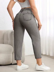 Detailed view of grey wash stretch denim jeans worn by a model in a bright indoor setting.