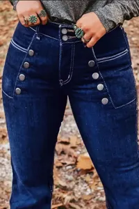 Gros plan sur un jean évasé bleu foncé taille haute avec boutons métalliques et coutures.