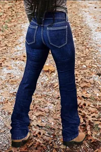 Jean flare bleu foncé en détail, avec coutures blanches classiques et coupe ajustée.