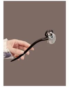 Detailed view of traditional Chinese wooden hair stick with crescent tassel ornament for Hanfu.