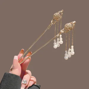 Traditional Chinese style gold hair sticks with elegant pearl tassels and hollow sphere design main view