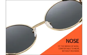 Primer plano de gafas de sol redondas de metal dorado con puente nasal cómodo y ajuste.