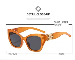 Amberkleurige jelly cat-eye zonnebril detailopname, trendy doorzichtig montuur met gouden scharnier.