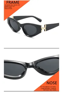 Vista detallada de elegantes gafas de sol negras de ojo de gato con patillas doradas y montura fina.