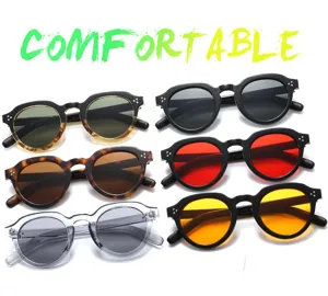 Occhiali da sole rotondi retrò con rivetti e lenti sfumate, stile casual per uomini e donne.