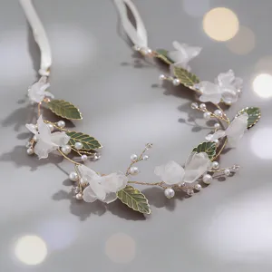 Elegant bridal hair vine with white chiffon flowers, green leaves and pearls for women.