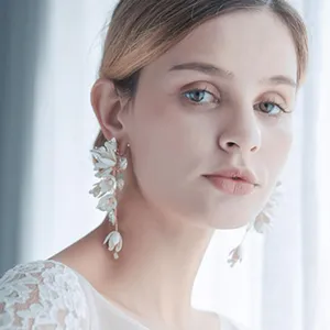 Elegant bridal floral drop earrings with gold leaves and white flowers for wedding styling.