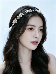 Elegant close-up detail of bridal pearl and rhinestone floral headband worn by model.
