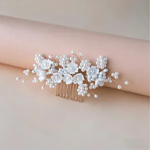 Handmade bridal pearl hair comb with white floral design for wedding party styling details.