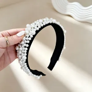 Detailed shot of a gorgeous black wide hair hoop densely decorated with multiple layers of pearls.