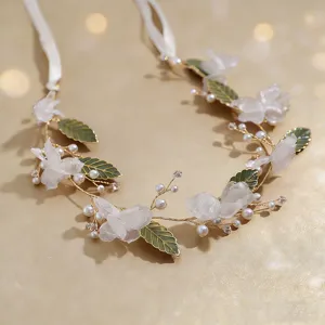 Elegant wedding hair vine with white fabric flowers, pearls, and gold leaves for women detail.