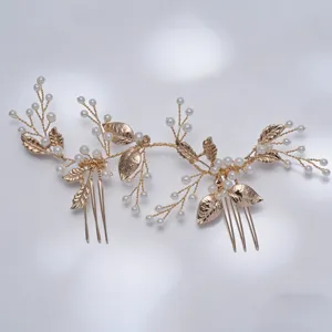 Detailed close-up of gold bridal hair comb featuring faux pearls and metallic leaf motifs.