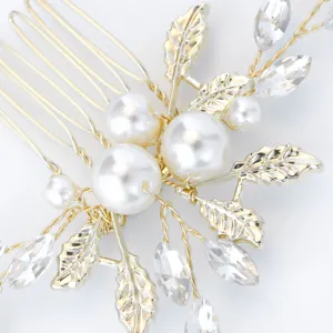 Gold bridal hair comb detail showing sparkling rhinestones, faux pearls, and delicate leaf metal accents.