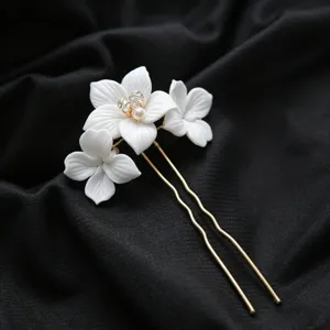 Détail d'épingle à cheveux en céramique florale artisanale, design blanc élégant.