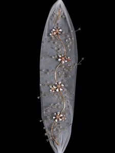 Bridal veil detail shot, handmade floral crystal hair accessory with elegant pearls.