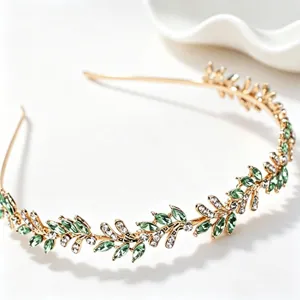 Detailed shot of the gold leaf headband with green crystals and rhinestones for elegant hair styling.