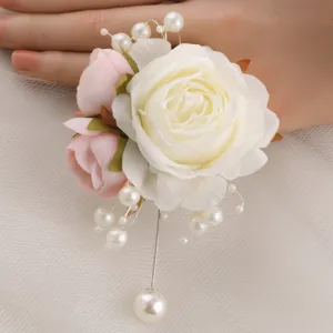 Beautiful artificial white rose and pink bud wedding wrist corsage with pearl pin main view.