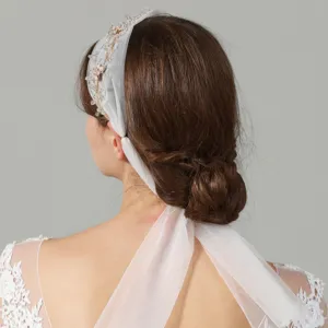Elegant French bridal hair band with handmade beads and sheer tulle veil for wedding dress.