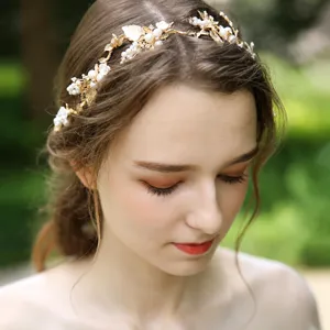 Stunning gold bridal headband featuring delicate alloy leaves and pearls, perfect wedding hair accessory.