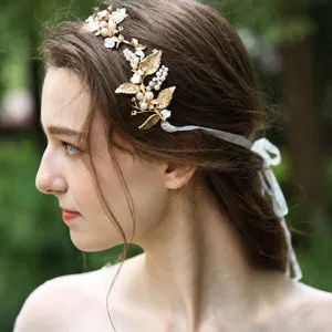 Bridal gold leaf headband with pearls and white ribbon, elegant wedding hair accessory.
