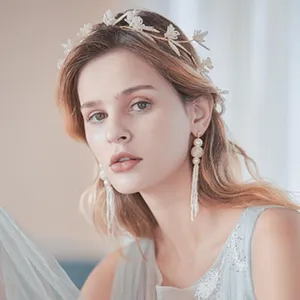 Exquisite handmade gold leaf bridal headband and elegant tassel pearl earrings detail view.