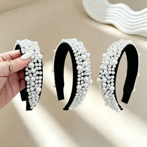Elegant pearl headband detail closeup, featuring handmade faux pearls on black fabric hoop.