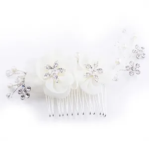 Gros plan détaillé du peigne à cheveux de mariée perlé avec fleurs blanches et strass brillants.