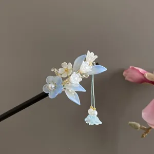 Gedetailleerd overzicht van de blauwe bloemige haarspeld met fijne kristallen details en kwastjes.