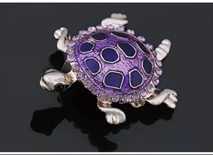 Detailed view of a charming turtle brooch featuring purple crystal rhinestones and enamel.