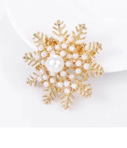 Elegant gold snowflake brooch adorned with shimmering pearls, perfect for sweaters and shirts.