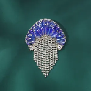 Detail van blauwe kristallen kwal broche, sprankelende strass steentjes kwast.
