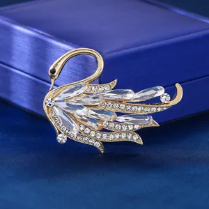 Detaillierte Nahaufnahme einer funkelnden Kristall-Schwan-Brosche mit Strass und Goldfinish.