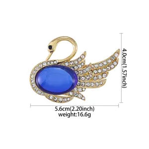 Elegante goldfarbene Kristall-Schwan-Brosche mit blauem Ovalstein und funkelnden Strasssteinen.