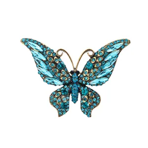 Vintage blue rhinestone butterfly brooch detail, elegant metal crystal insect lapel pin.