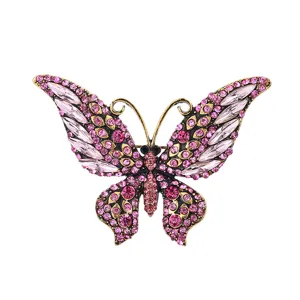 Exquisite butterfly brooch detail featuring vintage gold tone and sparkling pink crystals.
