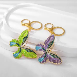 Close-up detail of metal enamel butterfly keychain with sparkling rhinestones and gold ring.