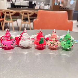Detailopname van acryl kerstboom vloeibare drijfzand sleutelhangers voor Kerstmis.