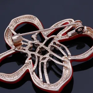 Detailed view of the gold-plated red enamel flower brooch back pin mechanism and clasp.