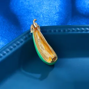 Close-up detail of the green enamel eggplant brooch back, showing metal pin and gold finish.