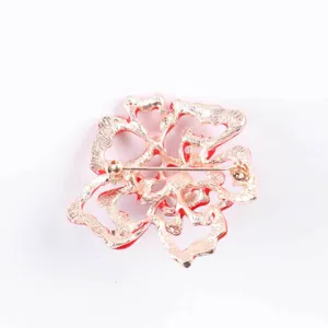 Close-up back view of the red enamel flower brooch showing secure pin mechanism.