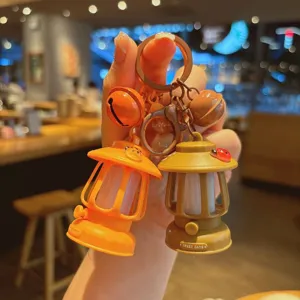 Close-up detail of the mini glowing camping lantern keychain, cute bag pendant and accessory gift.