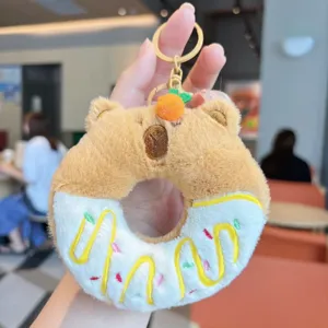Closeup detail shot of the cute plush capybara donut keychain with orange accent and metal ring.