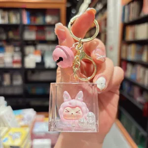 Portachiavi in acrilico con bambola di peluche rosa e campanella dorata molto carina.