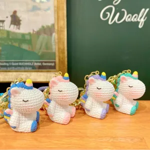 Closeup of cute resin unicorn keychains featuring textured knit design and colorful rainbow accents.