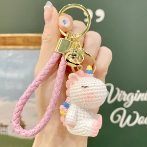 Close-up of the cute resin unicorn keychain detail, featuring a gold ring and pink strap.